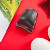 A close-up overhead shot of a Remington hair clipper on a red background, with a magazine and a comb visible. Náhled obrázku produktu