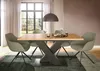 A dining table with chairs in a well-lit room with a large window. Produktbild-Vorschau