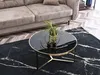 A round coffee table with a black marble top and gold legs is placed on a black marble patterned rug in front of a beige sofa. Náhled obrázku produktu
