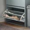 A close-up view of a light blue shoe cabinet with two open shelves, displaying shoes and slippers. Anteprima dell’immagine prodotto