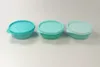 Three Tupperware containers of varying shades of turquoise are lined up on a white surface. Anteprima dell’immagine prodotto