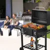A couple is enjoying a barbecue in a backyard setting, with a grill full of food in the foreground. Produktbild-Vorschau
