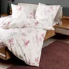 A close-up shot of a bed with floral patterned bedding. Produktbild-Vorschau