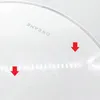 A close-up of a white product with the brand name embossed on it. Two red arrows are pointing down to different parts of the product surface. Voir les images du produit