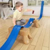 A young boy is playing with a toy car race track set indoors. Produktbild-Vorschau