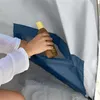 A person holding a bottle of sunscreen inside a beach tent. Voir les images du produit