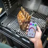 A person is holding a smartphone displaying a cooking thermometer app next to a roast beef cooking on a grill. Náhled obrázku produktu