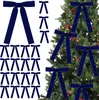 A collection of dark blue velvet bows arranged on a white background and on a decorated Christmas tree. Voir les images du produit