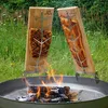 Two wooden boards with meat are being cooked over an open fire in a metal fire pit. Produktbild-Vorschau