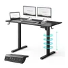 A black adjustable standing desk with two monitors, a laptop, keyboard, and mouse on top. A separate control panel is shown in the foreground. Blue rings indicate the desk's adjustable height. Anteprima dell’immagine prodotto