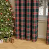 A Christmas tree with ornaments and gifts in front of plaid curtains. Voir les images du produit