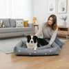 A woman petting her dog on a dog bed in a living room. Anteprima dell’immagine prodotto