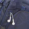 A close-up view of a blue backpack with white earbuds hanging from a loop. Produktbild-Vorschau