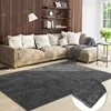 A living room scene with a sectional sofa, a rug, and shelves on the wall. Produktbild-Vorschau