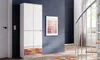 A tall white wardrobe with mirrored doors stands against a dark blue wall, next to a staircase. Produktbild-Vorschau