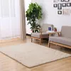 A beige rug is placed on a wooden floor in a living room setting with two chairs and a plant. Podgląd zdjęcia produktu