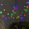 A string of colorful LED party lights is draped along a wooden wall and a darker wall, with some greenery visible at the bottom. Produktbild-Vorschau
