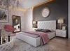 A modern bedroom with a large bed, bedside tables, and a decorative chair. Produktbild-Vorschau