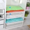 Vacuum sealed bags are neatly stacked on shelves inside a white closet or storage unit. Voir les images du produit