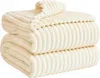 A stack of folded cream-colored blankets with a ribbed texture. Podgląd zdjęcia produktu