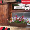 A brown planter box filled with colorful flowers sits on a brick ledge below a wooden window shutter and blinds. Náhľad obrázku produktu