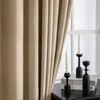A close-up of beige velvet curtains hanging next to a window, with black candle holders and candles on a table. Anteprima dell’immagine prodotto