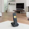 A cordless landline phone is placed on its charging base on a white table in a living room setting. Anteprima dell’immagine prodotto