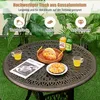 A round garden table with food and drinks on it, set on a green lawn with plants in the background. Produktbild-Vorschau