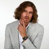 A man wearing a light gray suit jacket and a white shirt, posing with his hand on his chin. Podgląd zdjęcia produktu