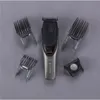 A hair clipper and its accessories are laid out on a gray surface. Podgląd zdjęcia produktu