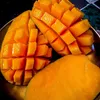 A close-up shot of a sliced mango, with some pieces cubed and others still in their skin. Produktbild-Vorschau