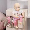 A doll is sitting on an open drawer of a nightstand, with clothes draped over the side. Podgląd zdjęcia produktu