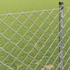 A close-up view of a chain-link fence with a grassy background. Voir les images du produit