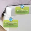 A close-up view of a bed with a duvet cover and a fitted sheet, highlighting product features with text overlays. Produktbild-Vorschau