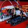 A close-up shot of electronic components, including a microcontroller board and a breadboard, connected by various colored wires. Anteprima dell’immagine prodotto