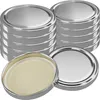 A stack of silver jar lids with one lid in the foreground showing the beige inner seal. Produktbild-Vorschau