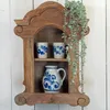 A wooden wall shelf with two mugs and a pitcher, decorated with blue floral patterns, and a hanging plant. Náhled obrázku produktu