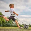 A young boy is practicing kicking a soccer ball with a training belt attached to his waist. Náhľad obrázku produktu