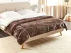 A bedroom scene with a bed covered by a brown faux fur blanket. Náhled obrázku produktu