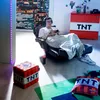 A young man is playing video games in a room decorated with Minecraft-themed items. Podgląd zdjęcia produktu