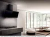 A modern kitchen with a black range hood over a stovetop, and a living area with a coffee table and floor cushions, viewed through a large window showing a snowy forest. Náhled obrázku produktu