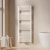 A white towel radiator is mounted on a light beige wall in a bathroom setting. A small wooden stool with a folded towel and some toiletries sits to the left, and the edge of a white bathtub is visible on the right. Náhled obrázku produktu