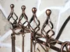 Close-up of decorative metalwork on a fireplace tool set. Podgląd zdjęcia produktu