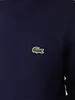 A close-up shot of a navy blue sweatshirt with a small green crocodile logo on the left chest. Anteprima dell’immagine prodotto