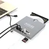 A silver external DVD drive connected to a laptop via USB-C, with an open tray and a CD inside. Several USB drives and memory cards are also visible. Produktbild-Vorschau