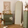 A bedroom scene with a tall arched mirror, two green dressers, a chair, and decorative items. Produktbild-Vorschau