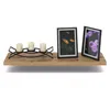 A wooden shelf with decorative items including a candle holder with three candles and two framed pictures of flowers. Produktbild-Vorschau