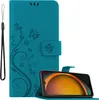 A teal flip-style phone case with a floral and butterfly design is shown open, with a smartphone inserted. A wrist strap is attached to the left side of the case. Produktbild-Vorschau