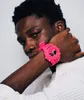 A close-up shot of a young person wearing a pink watch. Voir les images du produit