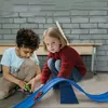 Two children playing with a toy car race track. Produktbild-Vorschau